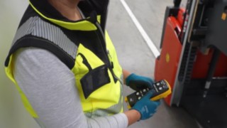An employee operates a Linde Material Handling L03 EX explosion-protected pallet stacker using a remote control.