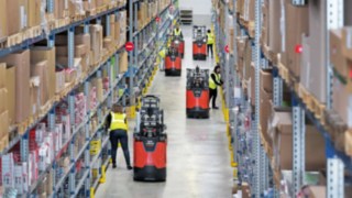 Employees work with order pickers of the new N20 series from Linde Material Handling in a warehouse.