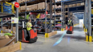 An order picker with Linde BlueSpot warns another truck at an intersection in the warehouse with a blue light.
