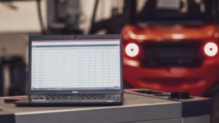 Laptop in front of a forklift truck from Linde Material Handling