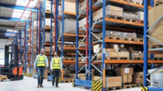 Yanmar Compact Equipment Europe employees walk through the new logistics centre, which was planned by Linde Material Handling.