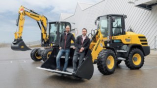 Dominik Haag and Markus Köhler from Yanmar Compact Equipment Europe Dominik Haag and Markus Köhler from Yanmar Compact Equipment Europe standing in the bucket of an excavator.