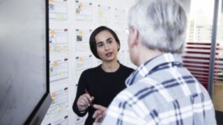 Young woman explains to Linde employee something on a chart Young woman explains to Linde employee something on a chart