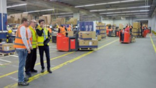 Three people analyse the occurrences in a factory building.