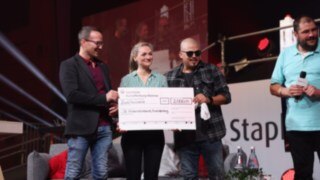 StaplerCup hilft e. V. supports the integration of disadvantaged children in the regions of Aschaffenburg, Alzenau and Miltenberg. Two men and a woman holding a donation cheque at the Stapler Cup