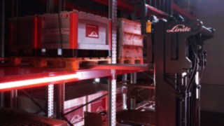 Linde reach truck Ri16 moving pallets in a racking area.