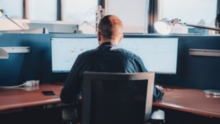 A Linde employee develops state-of-the-art automation solutions at KION Automation, working with CAD software on two monitors.