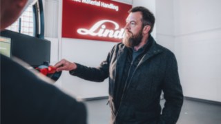 Two businesspeople discuss innovative intralogistics solutions that symbolize the future of intralogistics and customer focus in sales.